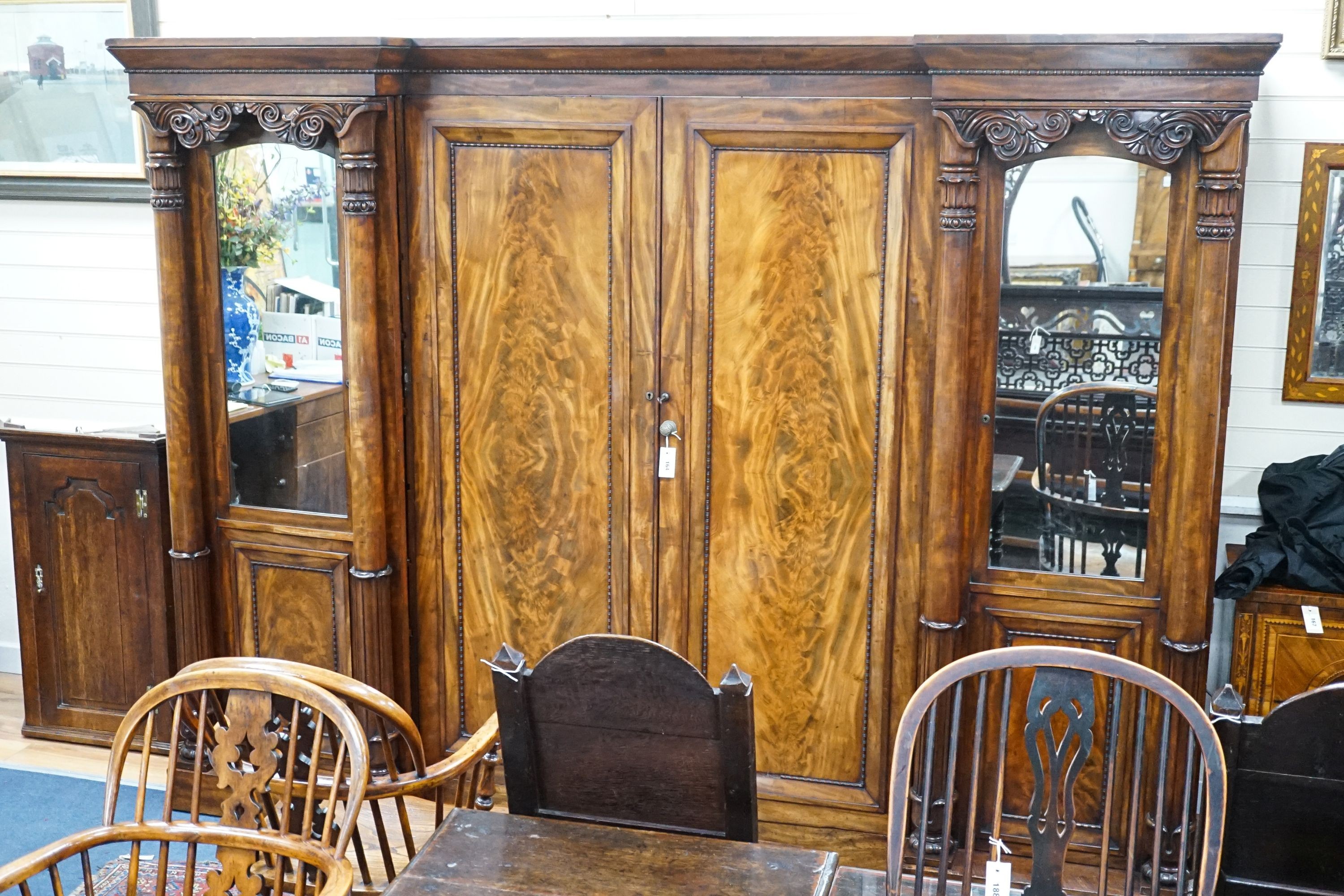 A William IV figured mahogany inverse breakfront compactum wardrobe, length 263cm, depth 70cm, height 197cm